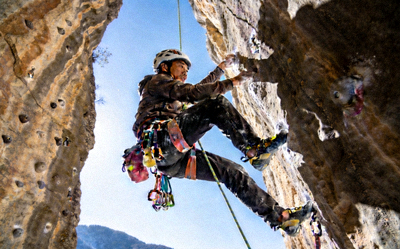 极限攀岩挑战场景：攀岩者在陡峭的岩壁上使用专业装备