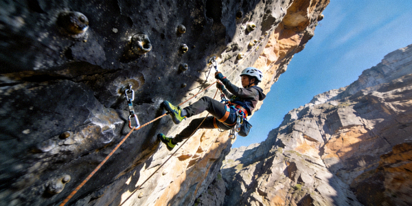 极限攀岩挑战场景：攀岩者在陡峭的岩壁上使用专业装备